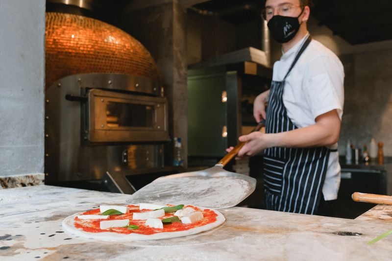 Pizza inn open kitchen where chefs craft pizzas in view of guests